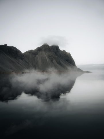 自然纪录片风格画面，雪山与湖泊在晨雾中展开，画面通透细节丰富，冷色调专业摄影质感